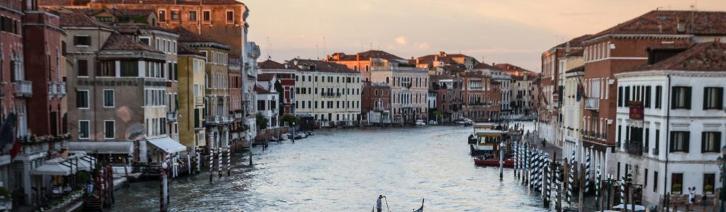 Person Standing on Floating Boat Between Houses